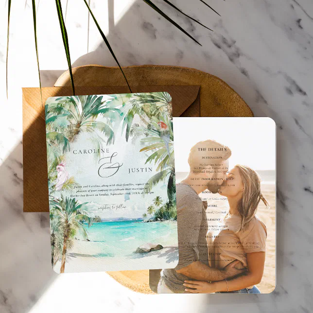 A tropical-themed wedding invitation. A couple kissing can be seen on one side and an ocean view can be seen on the other.
