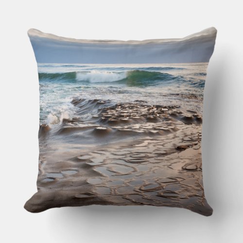 Wave breaking on beach California Throw Pillow
