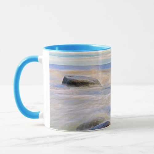 Waves crashing on shoreline rocks mug