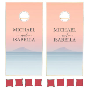 Wedding by the sea under peachy sky sunset cornhole set