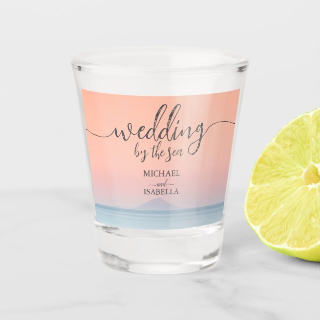 Wedding by the sea under peachy sky sunset shot glass (Front)