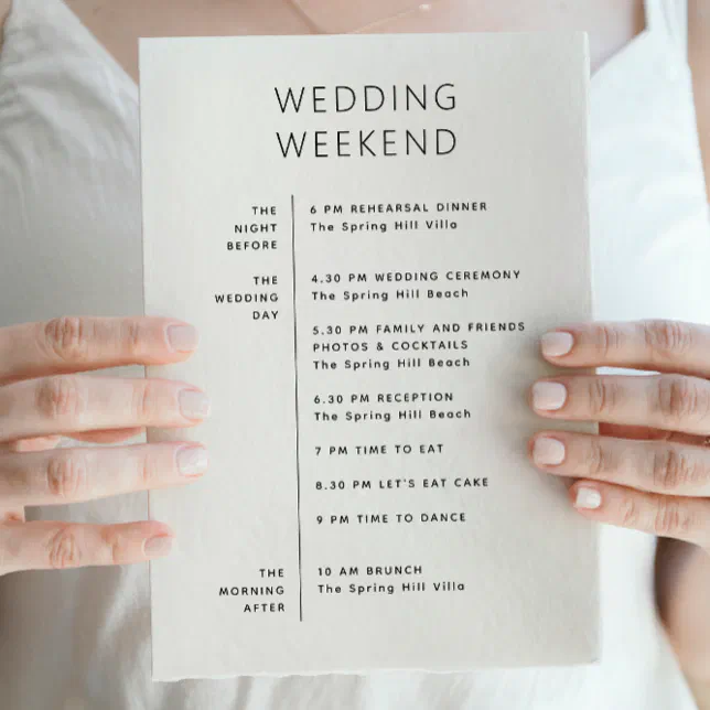 A wedding planner holds up the wedding weekend timetable, showing the list of activities that will be happening.