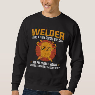 Welder using a High School Diploma to fix College Sweatshirt