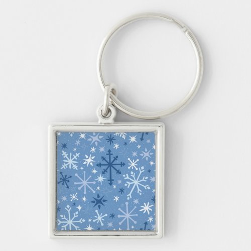 Whimsical flurry of blue snowflakes on sky blue keychain