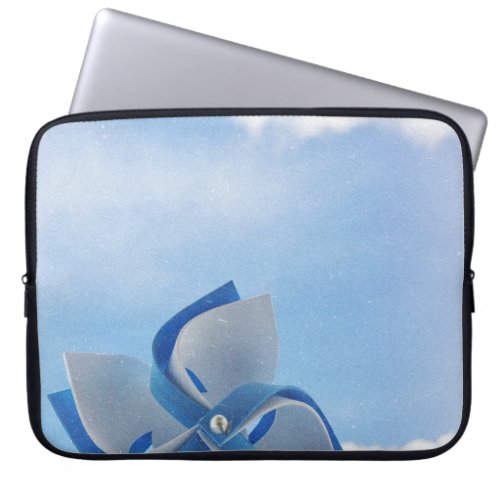 White and blue handheld windmill under cloudy skie laptop sleeve