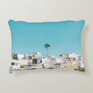 White and brown concrete houses under blue sky in accent pillow
