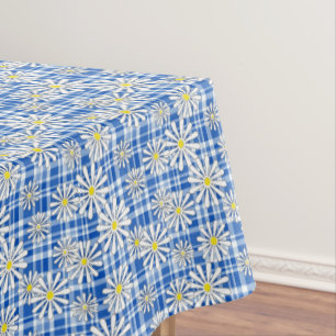 White chamomile flowers on a blue checkered backgr tablecloth