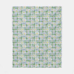 White chamomile flowers on a green blue checkered  fleece blanket