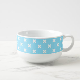 White cross stitches on baby blue soup mug