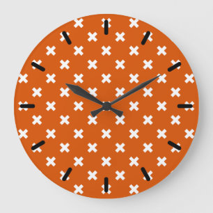 White cross stitches on burnt orange large clock