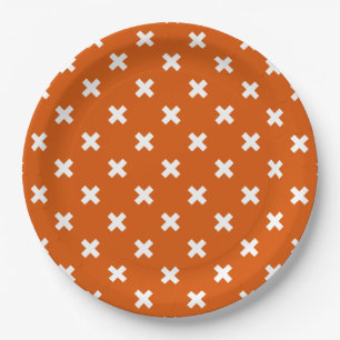 White cross stitches on burnt orange paper plates