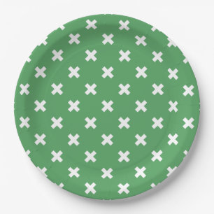 White cross stitches on green paper plates