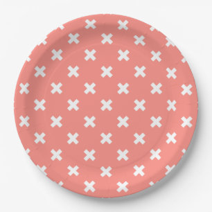 White cross stitches on peach paper plates