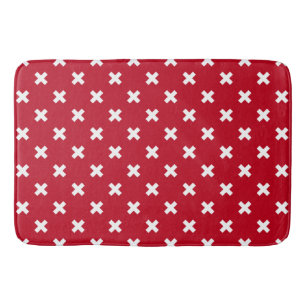 White cross stitches on red bath mat