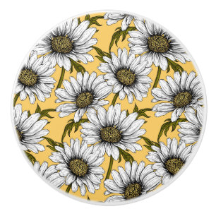 White daisies, wild flowers on yellow ceramic knob