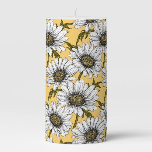 White daisies wild flowers on yellow pillar candle