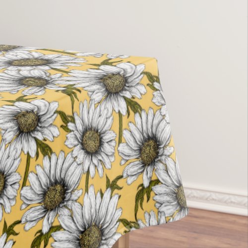 White daisies wild flowers on yellow tablecloth