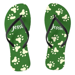 White dog paws on green flip flops