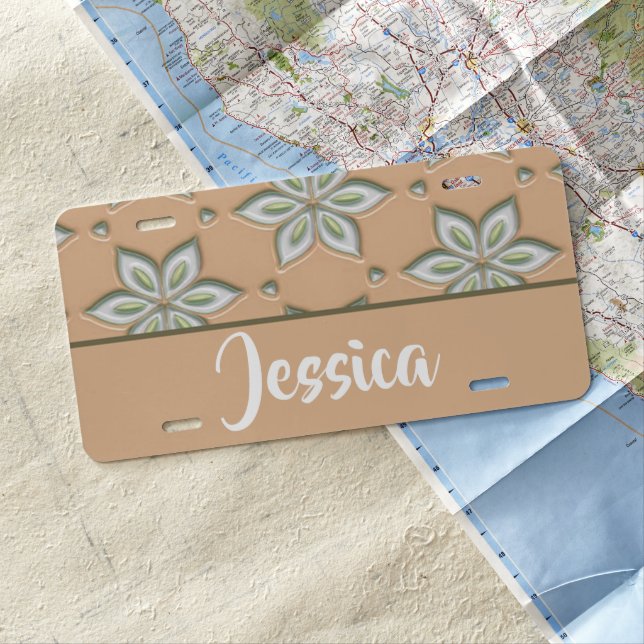 White engraved flowers on tan license plate (In Situ)