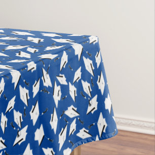 White Graduation Caps Tossed in the Air on Blue Tablecloth