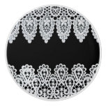 White lace forms a delicate border against black ceramic knob