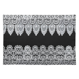 White lace forms a delicate border against black cloth placemat