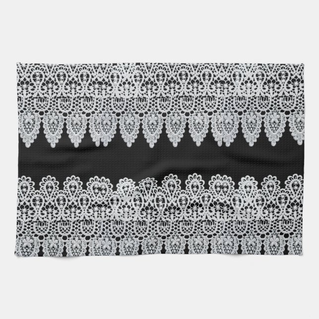 White lace forms a delicate border against black kitchen towel (Horizontal)