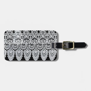 White lace forms a delicate border against black luggage tag