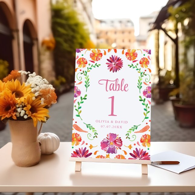 White Mexican Floral Fiesta Wedding Table Number (White Mexican Floral Fiesta Wedding Table Number on a wooden table next to flowers.)