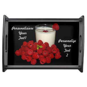 white milk with red raspberries on a black serving tray