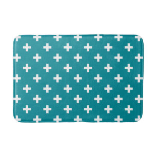 White polka crosses on teal bath mat