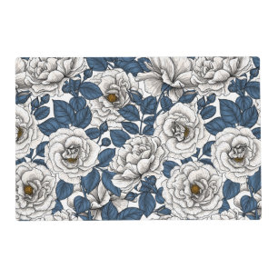 White roses with blue leaves on white placemat