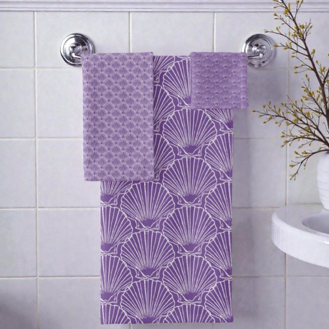 White Sea Shell Pattern Over Purple  Beach House Bath Towel Set (Seashell pattern bathroom towel set hanging on a rack on a bathroom wall.)
