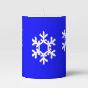 White snowflakes on blue pillar candle