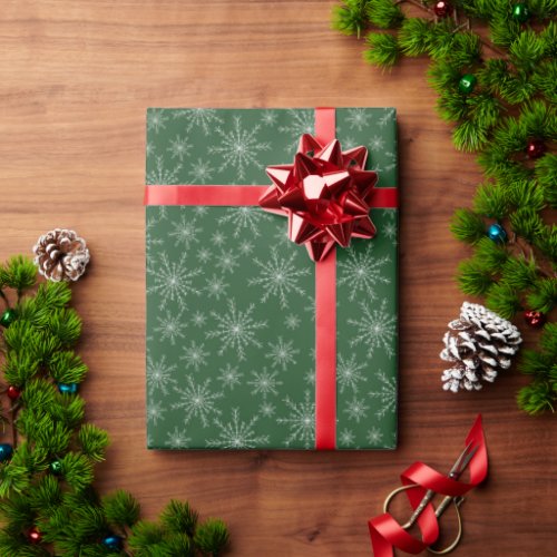 White snowflakes on green holiday wrapping paper