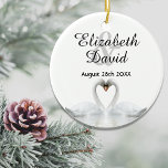 White swans in love with names wedding ceramic ornament<br><div class="desc">Two beautiful swans in love on a lake bending their heads toghether and forming a heart. White elegant background.  Template for your names and date. Black letters. 
A swan couple stay together for life,  so they are the perfect symbol of love.</div>