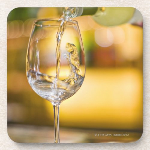 White wine is poured from bottle in restaurant coaster