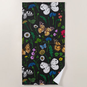 Wild flowers and butterflies on black beach towel