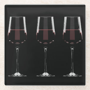 Wine glasses with red wine on black glass coaster