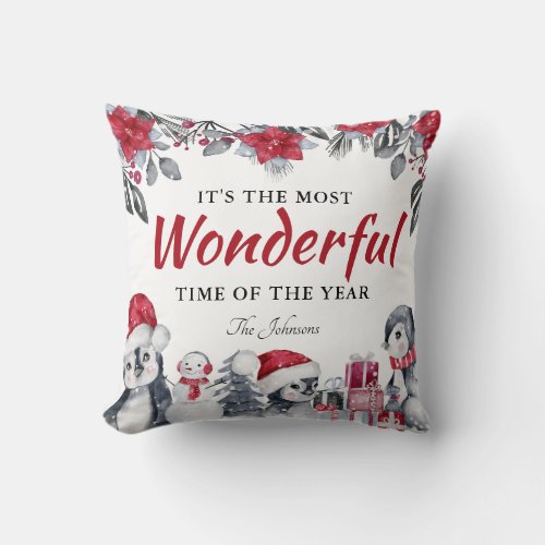 Winter Christmas Themed Throw Pillow - Winter christmas decor pillow featuring a simple white background, elegant watercolor xmas florals & foliage, cute baby penguins, a scattering of snow, the saying "it's the most wonderful time of the year", and your family name. The back of the pillow is a traditional festive red, but can be changed to any color.