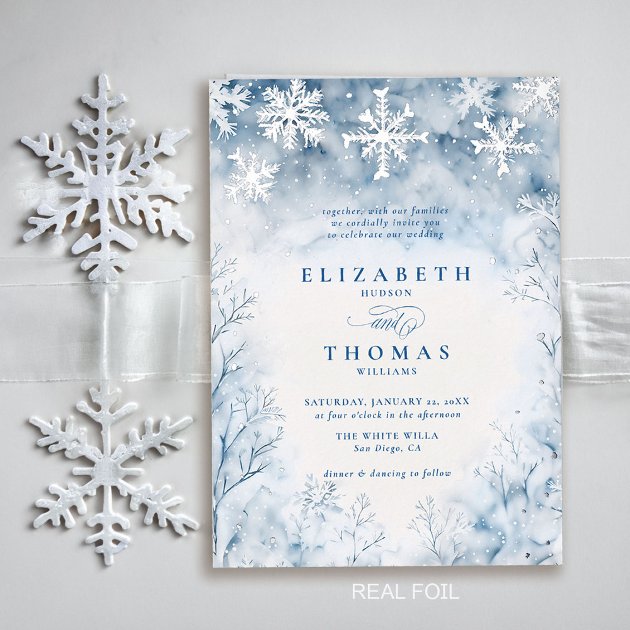 Luxury winter wedding invitation with real silver foil snowflakes over a watercolour winter forest