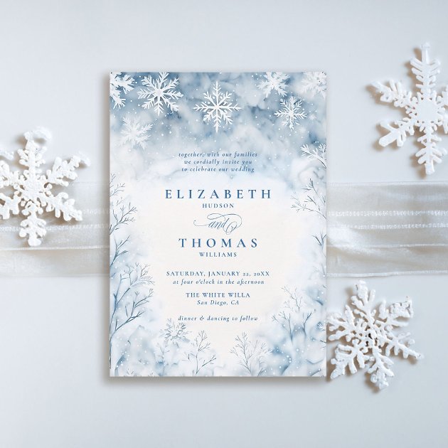 Winter wedding invitation showing watercolour snow falling over a frosted forest in soft blues and whites