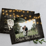Winter floral and barn wood save the date wedding announcement postcard<br><div class="desc">White cream flowers with seasonal foliage and rustic strings of twinkle lights on dark brown elegant barn wood photo save the date wedding postcard.           Easy to personalize with your names and text!            Suitable for floral winter,  summer or autumn fall / garden backyard rustic country or farmhouse themed weddings.</div>