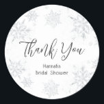 Winter Snowflakes Thank You Classic Round Sticker<br><div class="desc">"Thank You" in a fun script with event name framed by watercolor snowflakes in silver faux glitter. Coordinates with the Glitter Snowflake collection found in the Adore Paper Co. Zazzle Shop.</div>