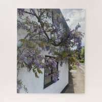 Wisteria growing against a white-walled cottage jigsaw puzzle