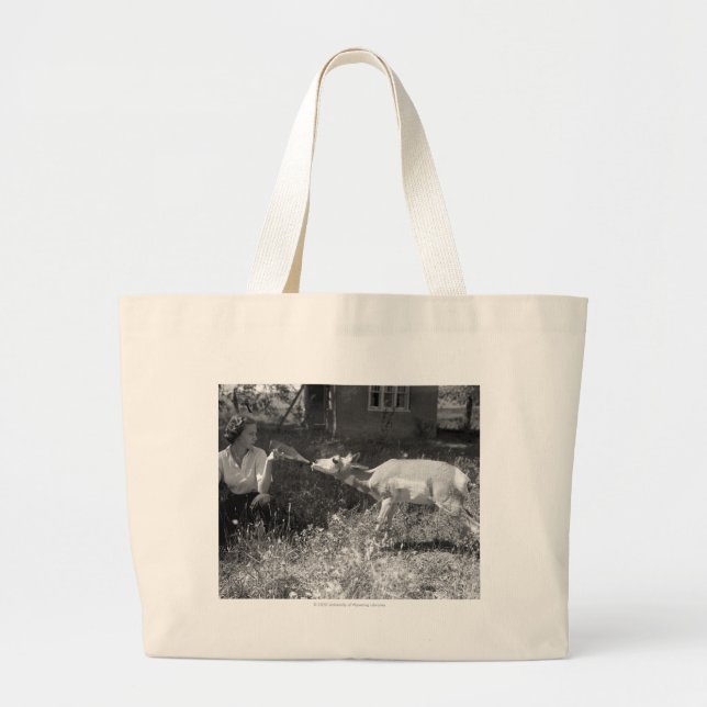Woman bottle feeding an antelope. large tote bag (Front)