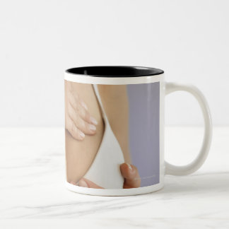 Woman doing breast self exam Two-Tone coffee mug