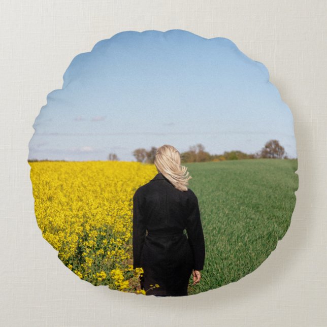 Woman in black coat standing on green grass field  round pillow (Front)