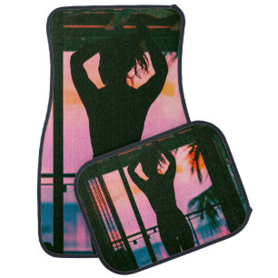 Woman in black tank top and pants standing on blac car floor mat