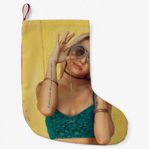 Woman in blue bralette holding sunglasses putting  small christmas stocking